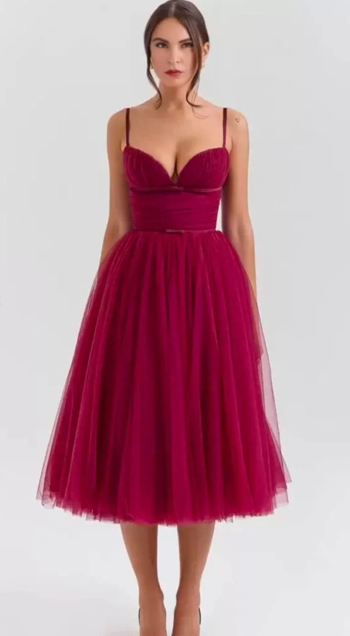 Woman wearing a sleeveless burgundy tulle midi dress with fitted bodice and spaghetti straps